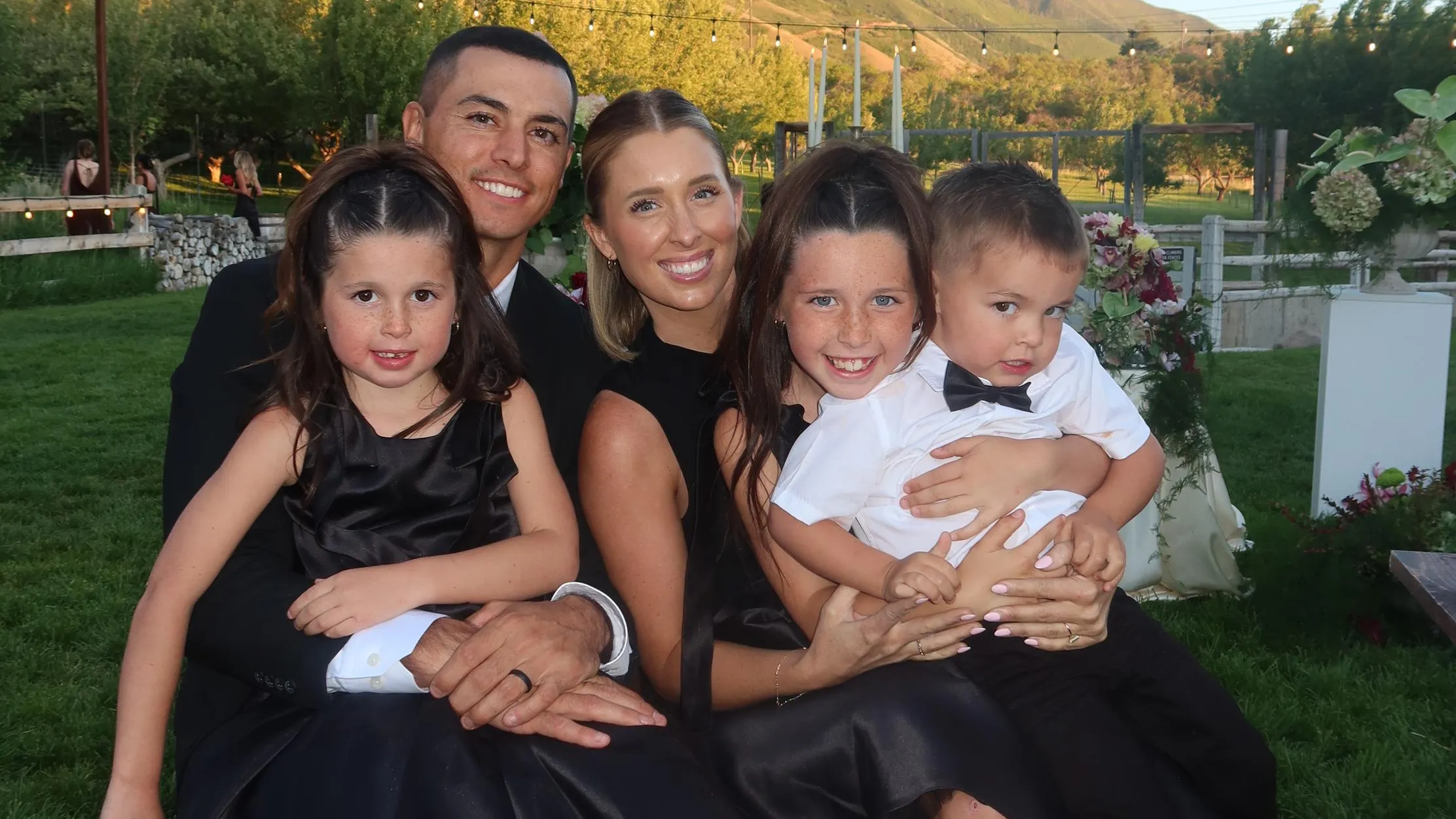 Steele and Cass McBride dressed up with their three kids at golden hour, mountains behind them