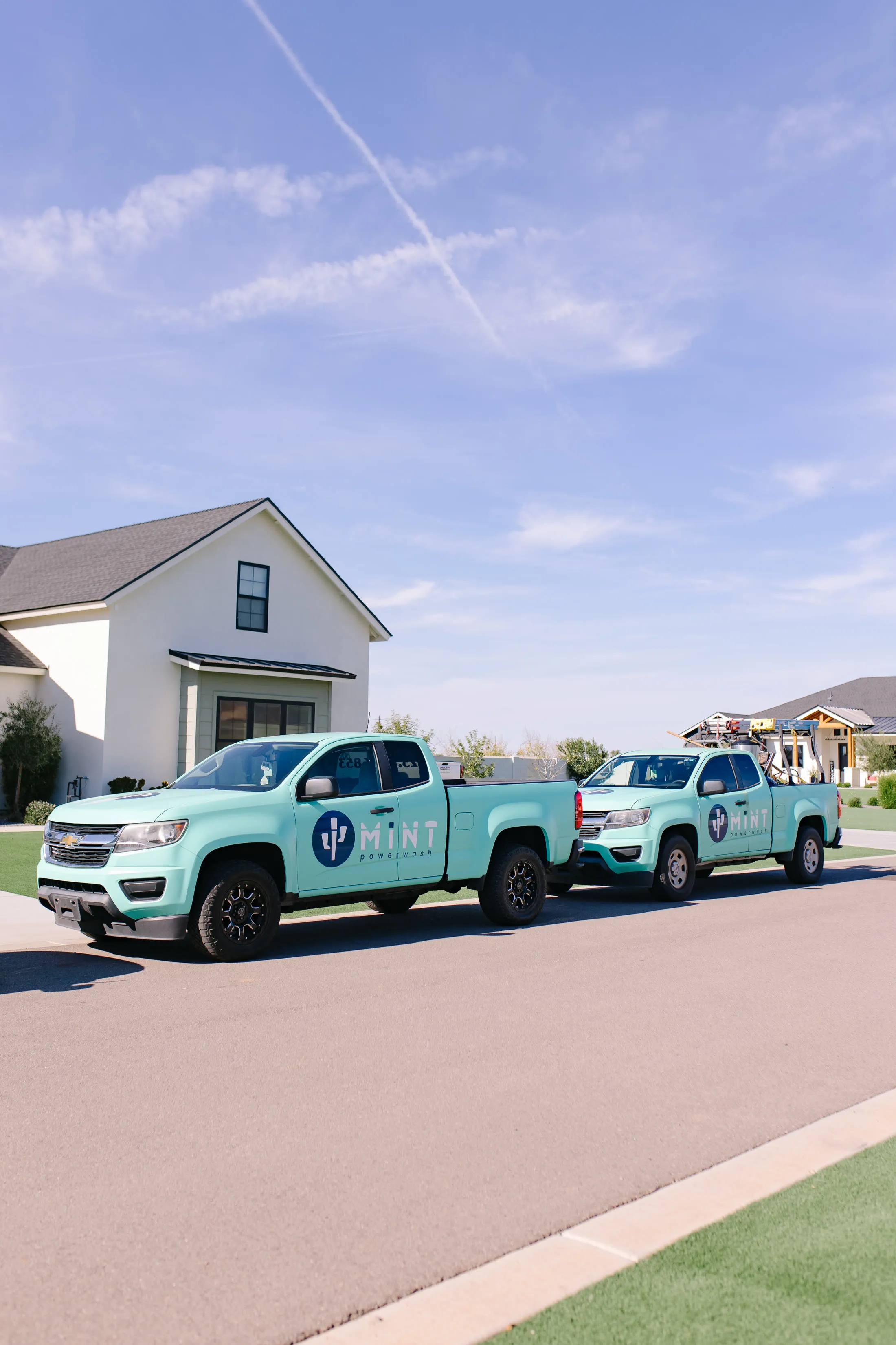 Two MiNT powerwash trucks parked on an East Valley street